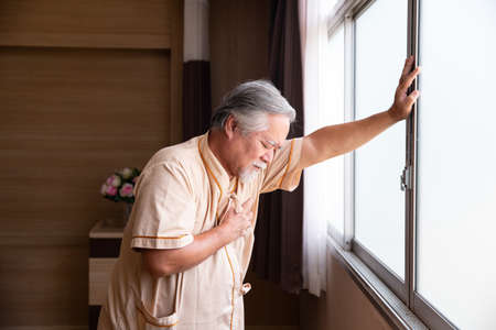 An elderly man with heart disease is being treated in a hospital room.の写真素材