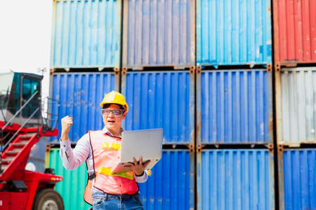 Foreman or Operator Ordering of moving containers via laptop computer. Foreman looking forward on Forklifts in the Industrial Container Cargo freight ship.の写真素材