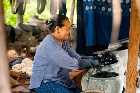 Older women dyeing cotton with natural indigo. Local Master are the original Indigo Cotton Weaving in the community of Sakon Nakhon province.の写真素材