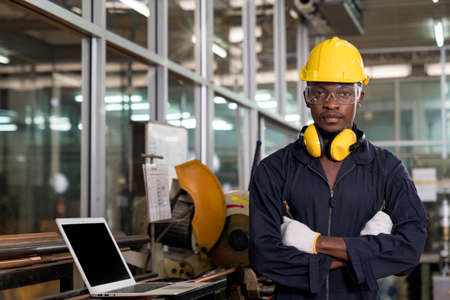 Manufacturing worker. Professional African-American worker controlling the work. Cheerful Factory...