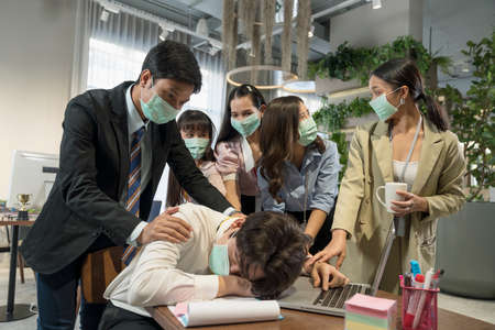 Company employees sick from viral infection. Covid virus 19. Employees at workplace during pandemic. Employees wear protective masks to prevent PM 2.5 dust and virus COVID-19.の写真素材