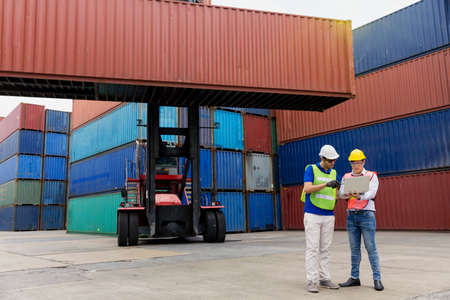 Foreman using laptop computer in the port of loading goods. Foreman operator ordering of moving...