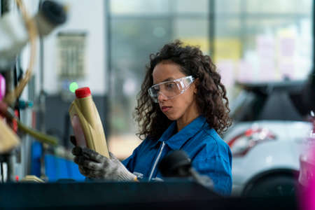 Auto mechanic hands using wrench to repair a car engine. Auto mechanic female automotive diagnostic...