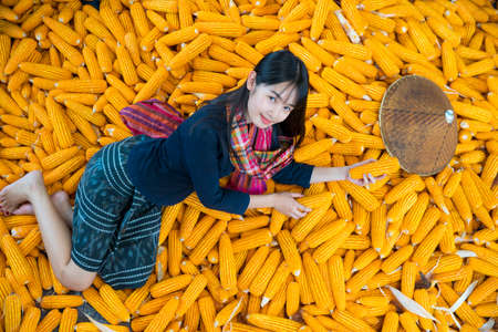 Rural life style concept. Girls in rural Thailand laying on corn harvested in the fields.