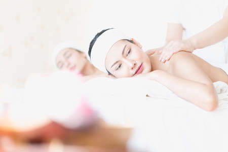 A young Asian woman getting a head massage It's in a spa shop. Young Asian girl relaxing with hand spa massage at beauty spa salon.の写真素材