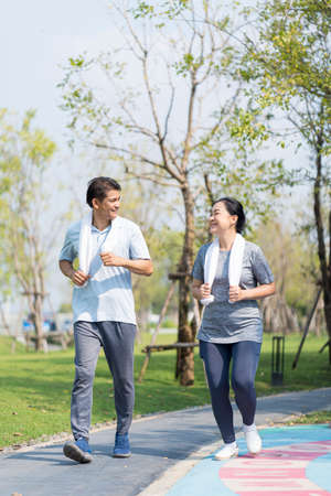 Couple doing exercising by running in the garden. Happy senior couple exercising in the park.の写真素材