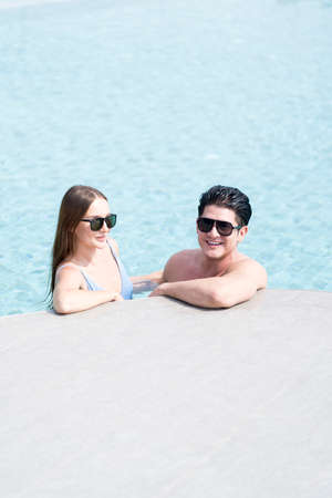 Man and woman in a swimming pool. Young couple embracing in the pool.