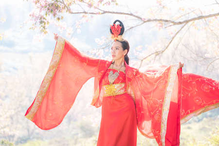 Chinese girl wearing Ancient chinese dress or Cheongsam dress Traditional Chinese dress with Cherry blossoms.の写真素材