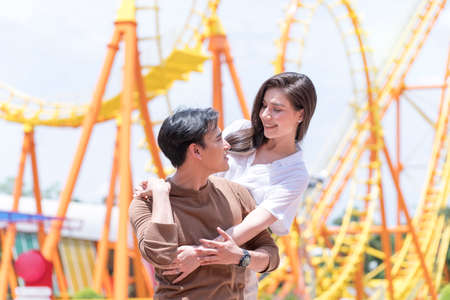 Couple dating relaxation love theme park. A couple standing at the roller coaster ride.の写真素材