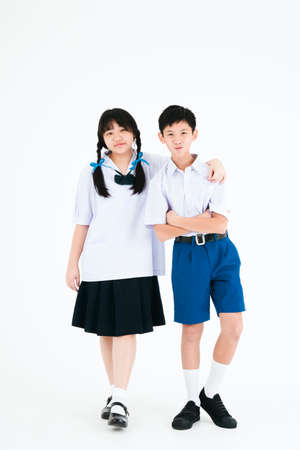Back to School. Boy and girl wearing high school uniforms of Thailand. Children on white background.の写真素材
