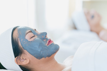 Woman with facial mask in beauty spa. Beautician doing facial mask.の写真素材