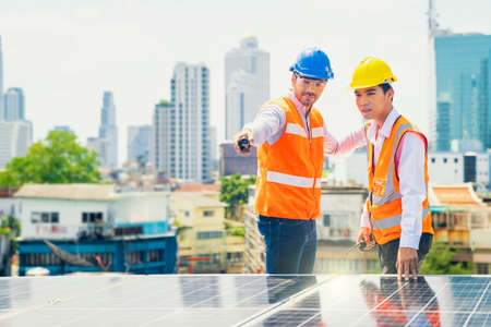 Foreman and Worker maintaining solar energy panel. Technicians checking part and equipment for solar...