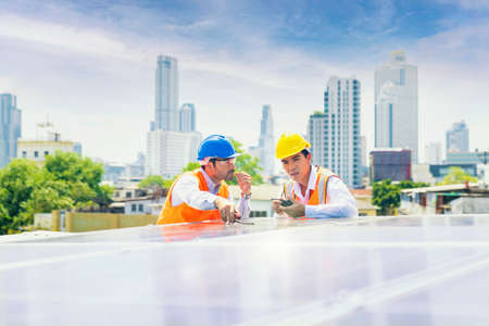 Foreman and Worker maintaining solar energy panel. Male engineers discussing malfunction of solar...
