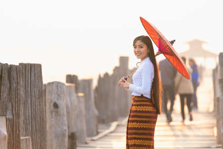 A Burmese girl walks on a bridge at a major tourist attraction in Mandalay Province, Myanmar.の写真素材