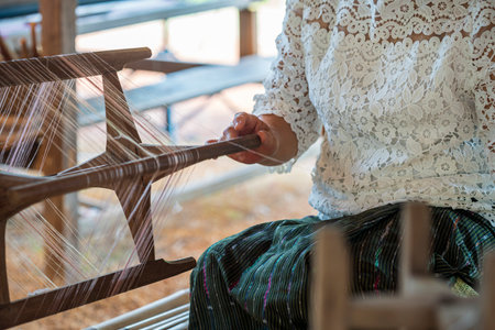 Thai old woman shows weaving spinning natural colorful threads or yarn. Nong khai, Thailand.