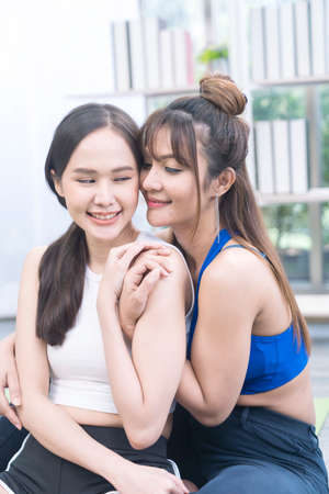 Healthy lifestyle concept for friends or couple. lesbian couple exercising in the living room.の写真素材
