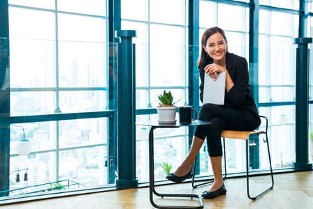 Businesswoman smile using digital tablet and looking camera. Happy businesswoman using digital tablet.の写真素材