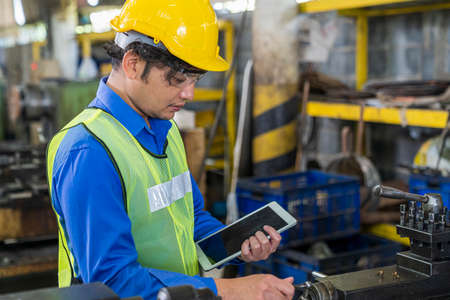 Professional technician holding a tablet in an industrial factory