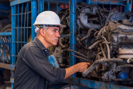 Engineers using tablet in the factory. A skilled mechanic inspecting auto parts in a factory.
