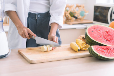 Healthy living and Vegan food. Cooking vegan food. Chef is cutting Banana to decorate a salad.の写真素材