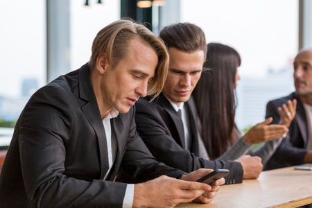 Indifferent businessman expressing empathy in the office. Businessman using mobile phone.の写真素材