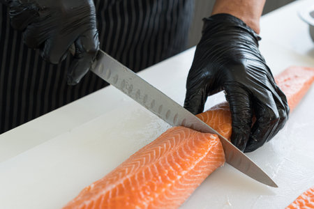 Japanese chef cleaning salmon. A worker cutting salmon on a board.の写真素材