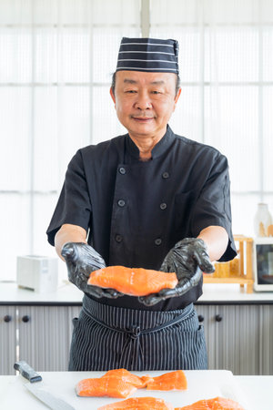 Japanese Chef showing salmon meat. The salmon is in the hands. Fresh Salmon slices.の写真素材