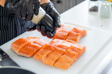 Chef preparing a fresh salmon. Japanese Chef sprinkle salt on salmon meat.の写真素材