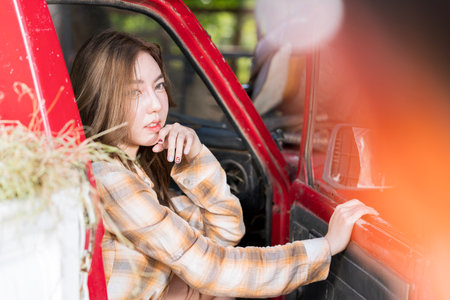 Beautiful cowgirl in the stable. Cowboy girl. Cheerful pretty young woman cowgirl with truck.の写真素材