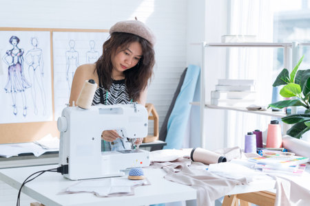 Fashion designer working in the studio. a woman using sewing machine.の写真素材