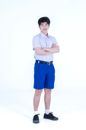 Students in uniforms are standing with their arms crossed. Young asian teenager arms crossed on white background.の写真素材