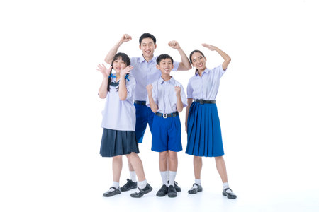 Group of Asian students wearing school uniforms on a white background. Girl and boy standing together friendly in Thailand students uniform.の写真素材