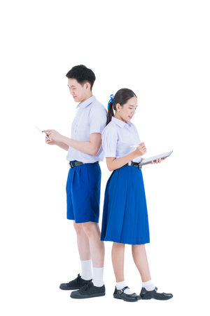 Group of Asian students wearing school uniforms on a white background. Boy and girl Smiling and using Table computer.の写真素材