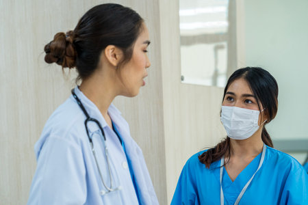 Cheerful young doctor listening to a patient in the hospital.の写真素材