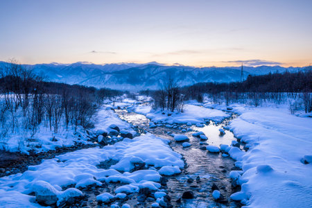 Winter landscape of the mountain stream. Snow-covered stream in Hakuba, Japan.