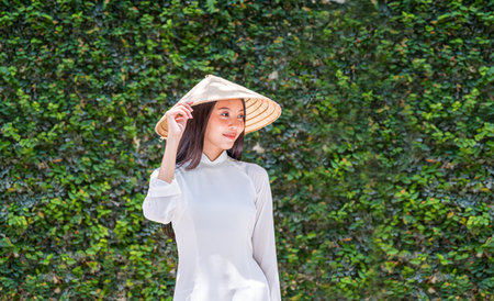 A young woman in Vietnam checks the features of a green wall periodically.