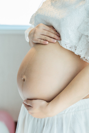 Close up of pregnant woman at homeの写真素材