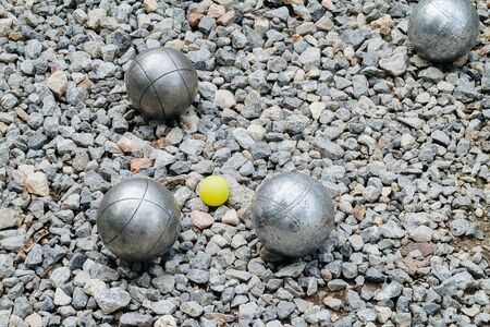 Petanque balls and the yellow wood jack on the groundの写真素材