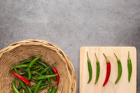 Pepper of thailand in the wooden basket and on the wooden cutting board placed on the black cement...