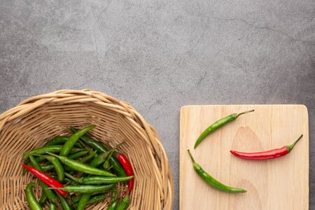 Pepper of thailand in the wooden basket and on the wooden cutting board placed on the black cement...