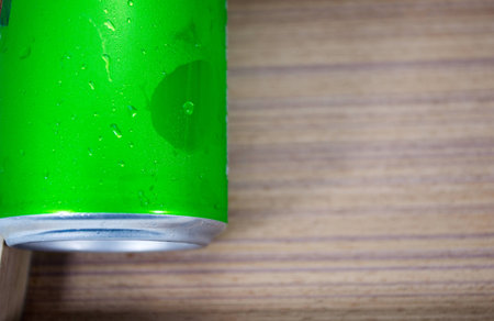 Drink chilled cans green and with water drops attached. There is a wood background, focus water drops.の写真素材