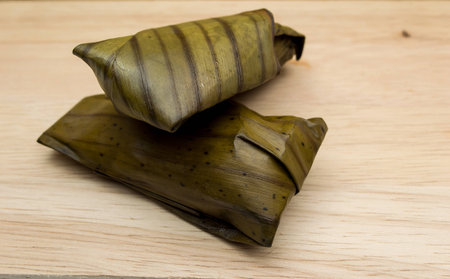 Khao Tom Mad or Khao Tom Pad,Bananas in Sticky Rice,Thai cuisine on wood backgroundの写真素材