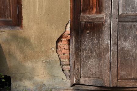 The old brick wall  with door and window frames made of teak wood.の写真素材