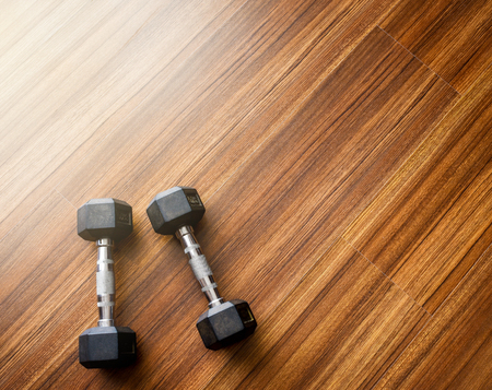 Two dumbbells weight 3 kg.each on wood background.Soft light effect added.の写真素材