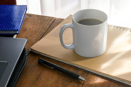 Coffee cup on the working desk at home,touched by the morning sunlight.の写真素材