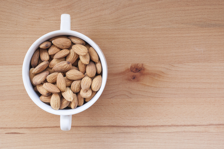 Almonds on a white background, or on a plain wooden table.の写真素材