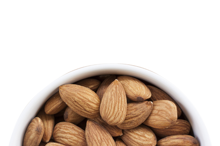 Almonds on a white background, or on a plain wooden table.の写真素材