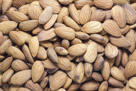 Almonds on a white background, or on a plain wooden table.