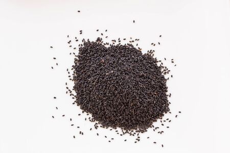 black sesame seeds on spoon isolated on white background.の写真素材