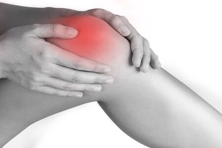 women has inflammation and swelling cause a pain the sore knee, isolated on white background.の写真素材